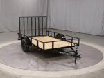 Pillowle 6’4” x 10’ carry-on utility trailer with black metal frame and wooden floor, suitable for light transport and camping.