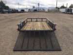 Pillowle 6’4” x 10’ carry-on utility trailer with black metal frame and wooden bed, designed for light hauling and transport.